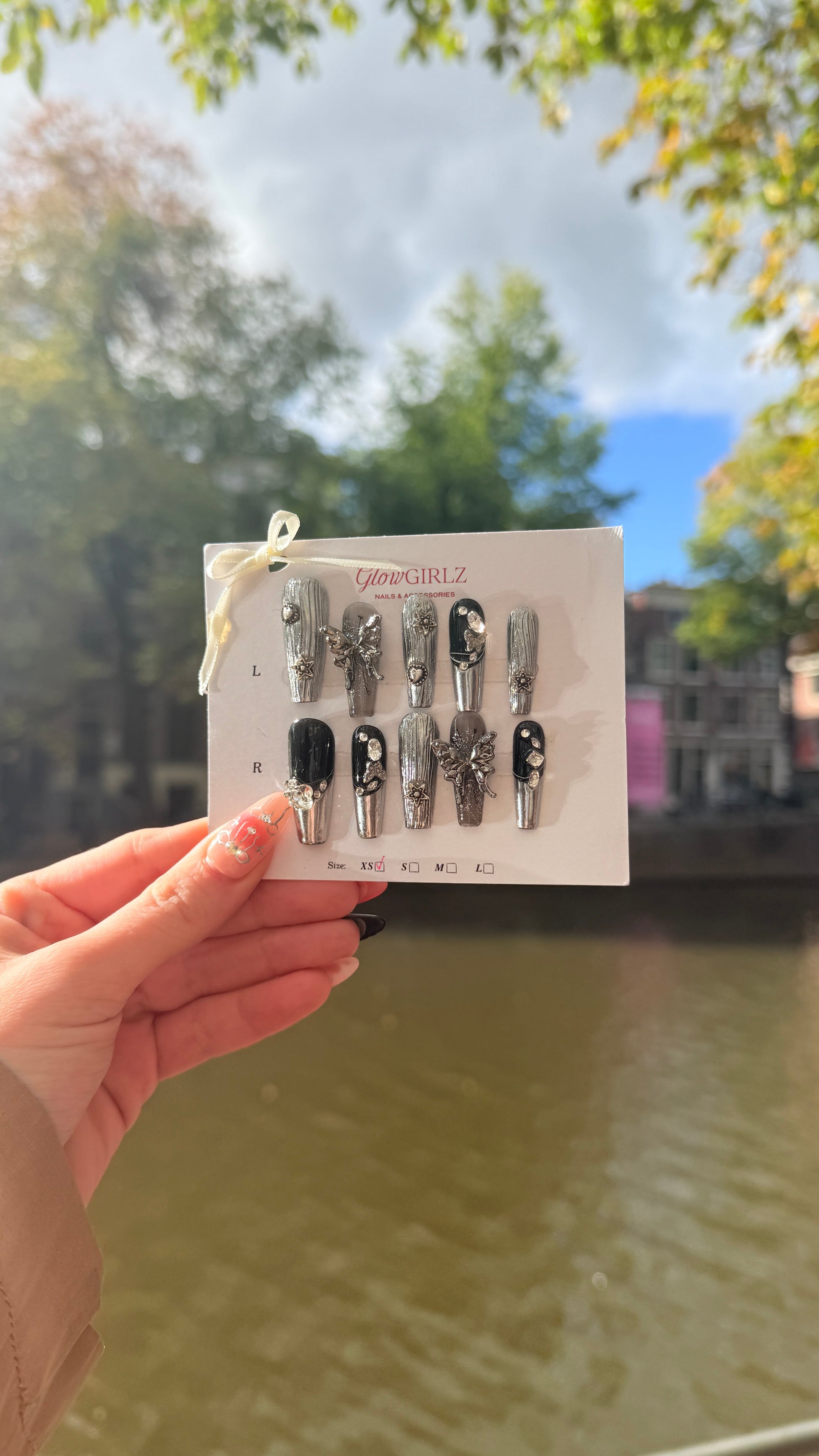 Set of nails on a card held by a hand with a blurred background