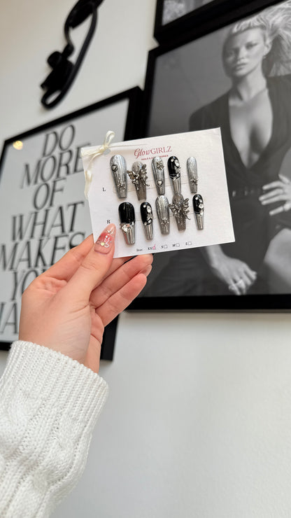 Hand holding a card with nail designs in front of a framed picture